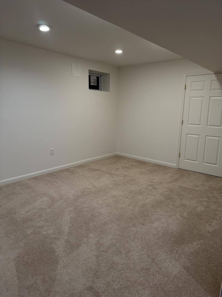 Finished basement room with freshly vacuumed carpet after a move out clean