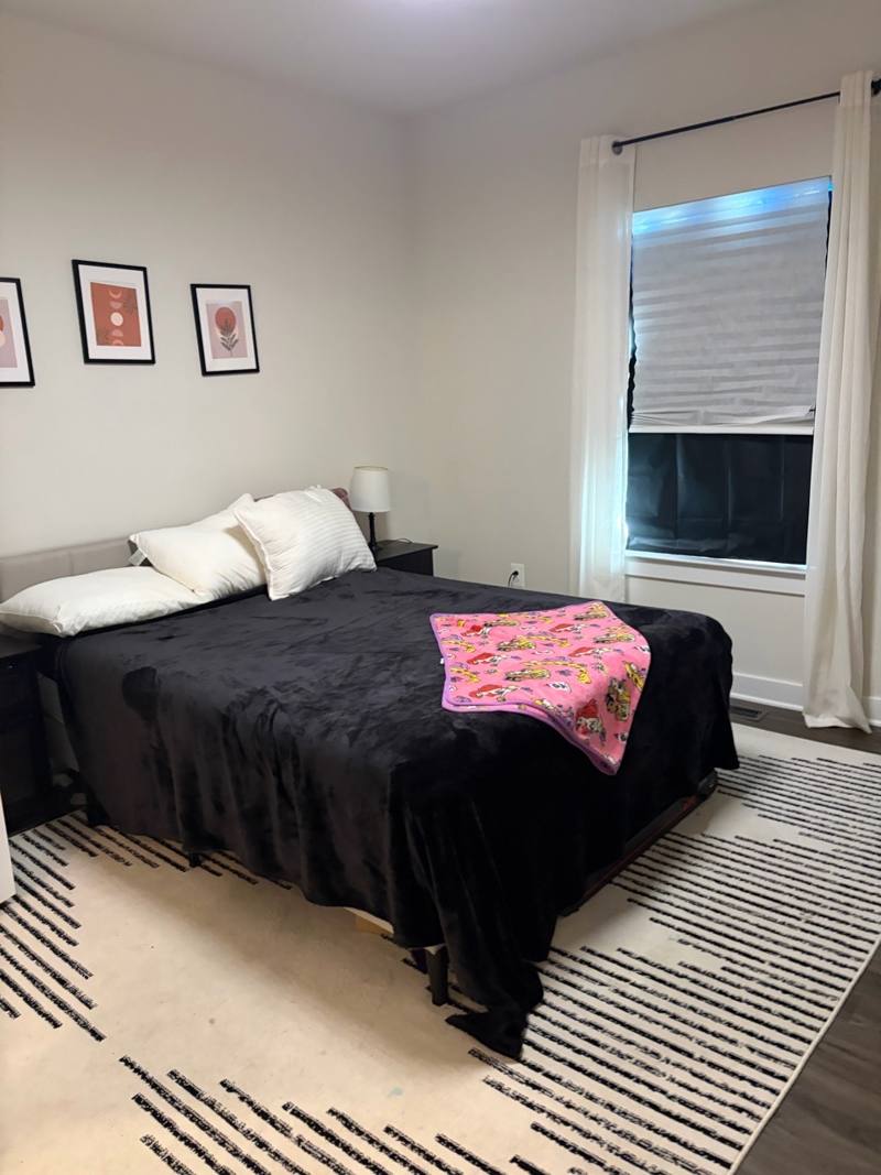 Bedroom with made bed and clean floors after a deep house cleaning