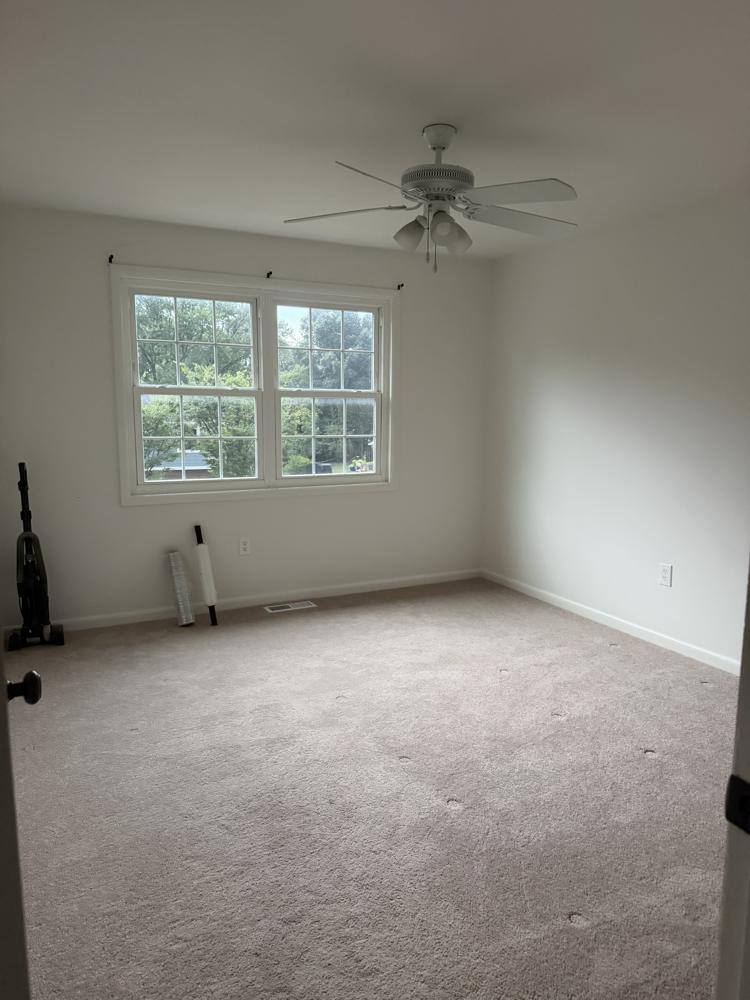 Empty bedroom with clean carpet and windows after a move cleaning
