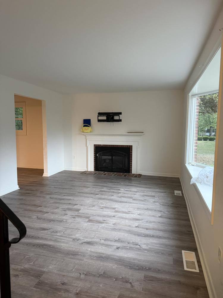Empty living room with fireplace after a move out cleaning in Maryland